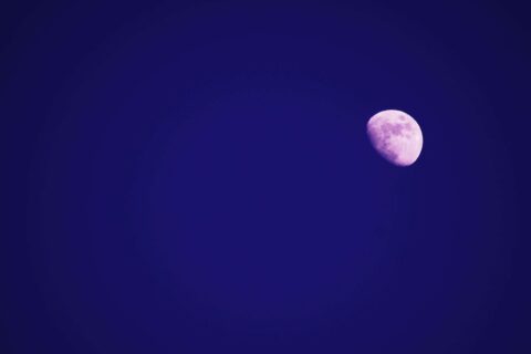 Captivating image of the moon shining brightly in a clear deep blue night sky.