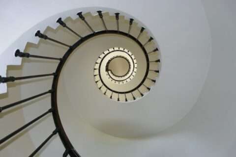 Elegant spiral staircase captured from above, showcasing architectural design and symmetry.