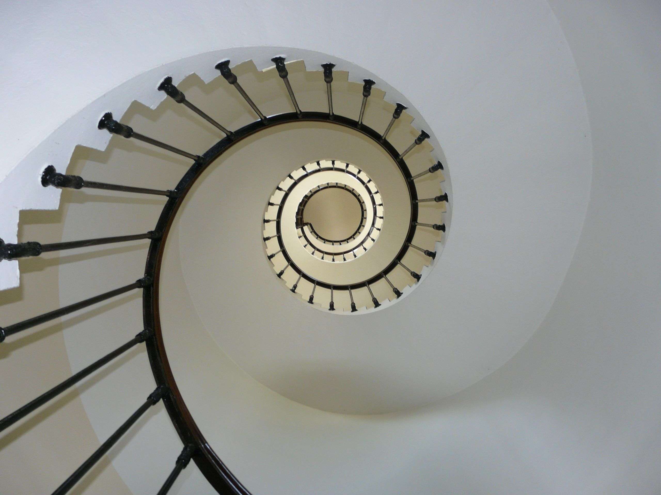 Elegant spiral staircase captured from above, showcasing architectural design and symmetry.